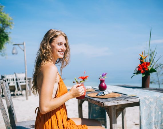 Cheerful female spending carefree time in beach restaurant